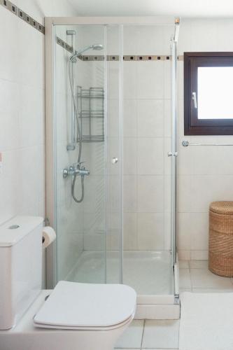 a bathroom with a glass shower with a toilet at Mountain view 6 bed mansion with Private Padel Court, Pool & Gym in Larnaca