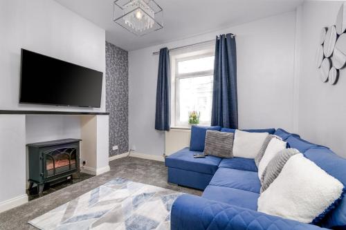 a living room with a blue couch and a fireplace at Hope Street in Filey