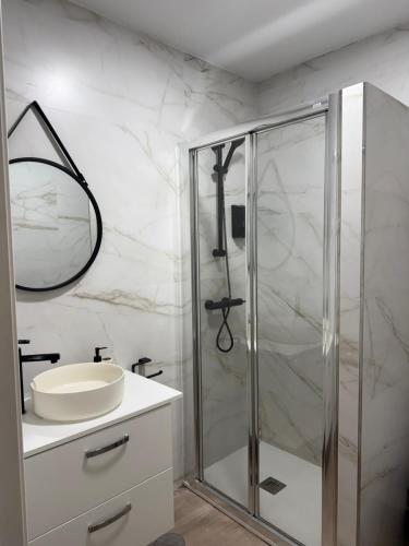 a bathroom with a glass shower and a sink at PENSIÓN ISBEL in Málaga
