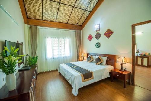 a bedroom with a large bed and a window at Hoa Binh Resort in Hòa Bình