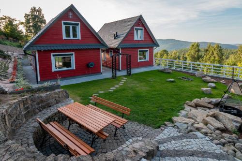 a red house with a picnic table and a playground at Domki w Jarzębinach - Domek z widokiem in Piechowice