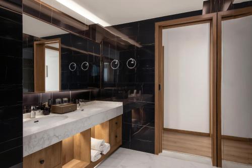 a bathroom with two sinks and a large mirror at Yangshuo Gallery Resort--River View, Sunset,Cafe,Karast Mount,Ten-Mile Gallery,Free Laundry,Travel Guide,Book Tickets in Advance,E-Scooter Service in Yangshuo