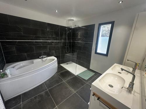 a bathroom with a bath tub and a sink at villa des gorges in Vagnas