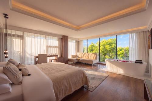 a bedroom with a large bed and a large window at Yangshuo Gallery Resort--River View, Sunset,Cafe,Karast Mount,Ten-Mile Gallery,Free Laundry,Travel Guide,Book Tickets in Advance,E-Scooter Service in Yangshuo