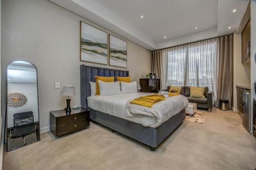 a bedroom with a large bed and a couch at Sandton Skye Unit 1110 in Johannesburg