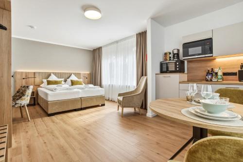 a hotel room with a bed and a dining table at Colleen Apartments Wesertal in Porta Westfalica