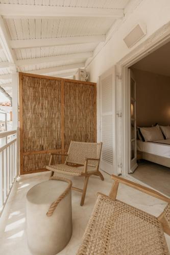 un soggiorno con una poltrona e un letto di TRINITY THE HOTEL ad Ammouliani