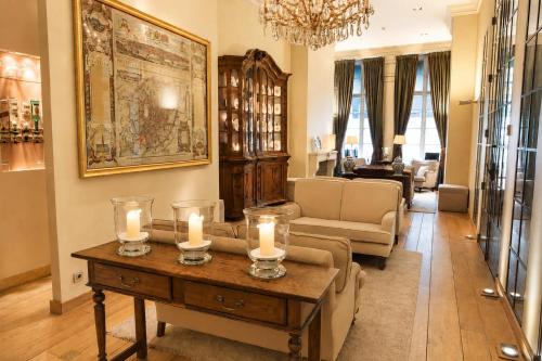 a living room with a couch and candles on a table at Hotel Le Dixseptième in Brussels