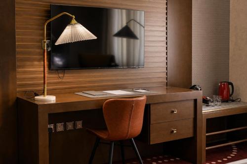 a desk with a lamp and a desk with a chair at Redwaves Hotel in Jeddah