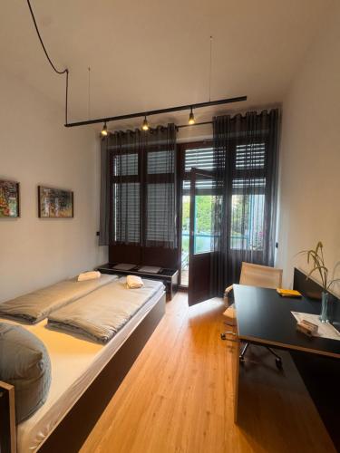 a bedroom with a large bed and a desk at Estelada Studios Unterhaching in Unterhaching