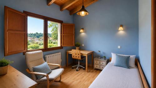 a bedroom with a bed and a desk and a window at La Casa de Pría in Garaña