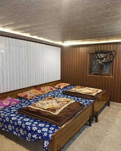 two twin beds in a bedroom with wooden walls at Himalayan siddhi yog aashram in Badrinath