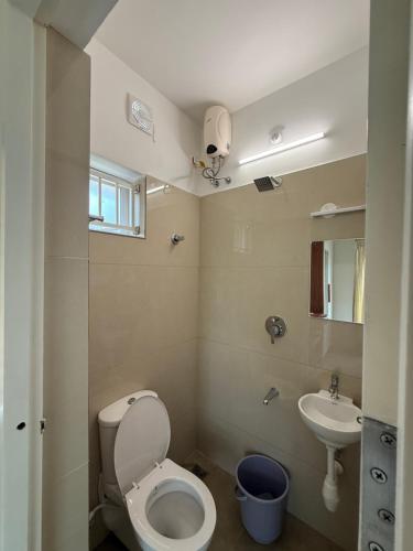 a small bathroom with a toilet and a sink at Little Retreats in Nedumbassery