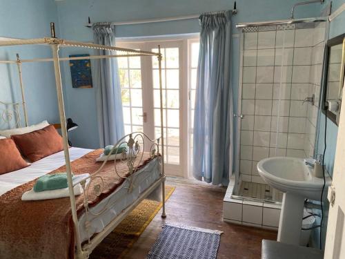 a bedroom with a bed and a shower and a sink at Port Nolloth Beach Shack in Port Nolloth