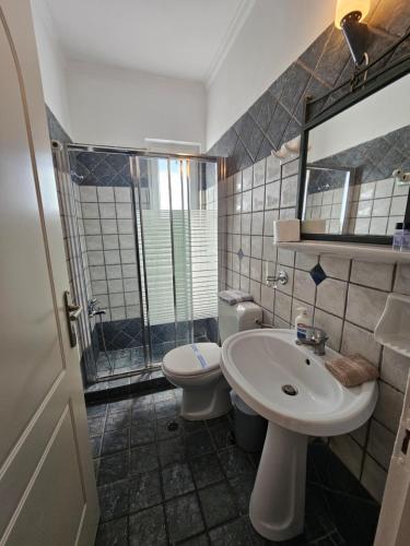 a bathroom with a sink and a toilet and a mirror at Amfitrion Apartments in Gythio