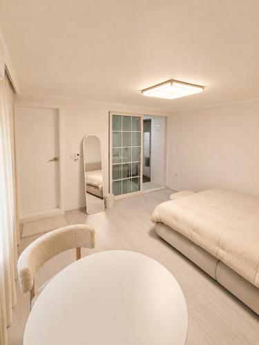 a white room with a bed and a table at Coco Villa Sinsa in Seoul