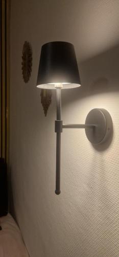 a lamp sitting next to a bed in a room at Urban Duo Saumur in Saumur