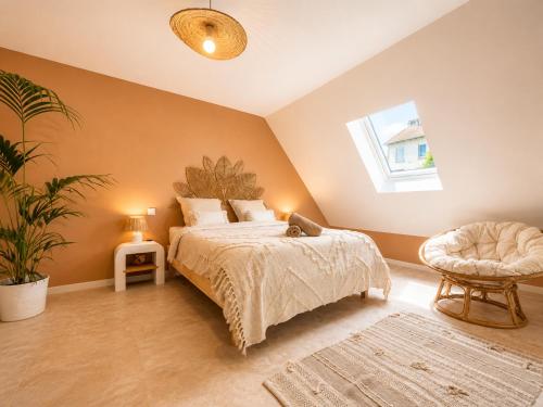 a bedroom with a bed and a chair and a window at Voyage à Bali in Sarreguemines