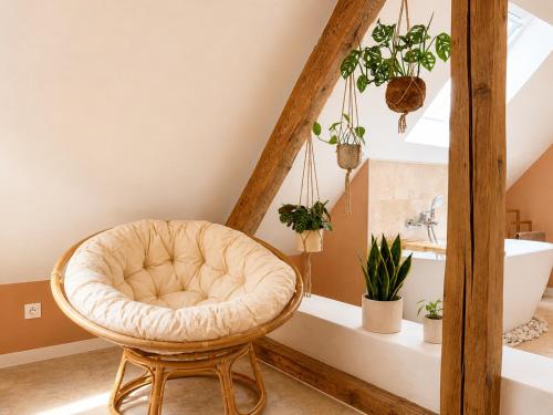a room with a chair and a bathroom with plants at Voyage à Bali in Sarreguemines