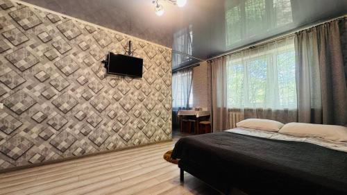 a bedroom with a bed and a tv on a wall at Vinnytsia, Vyshenka in Vinnytsya