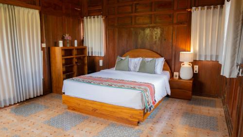 a bedroom with a large bed with wooden walls at Villa Uma Sawan By 25Hours Hospitality in Bedahulu