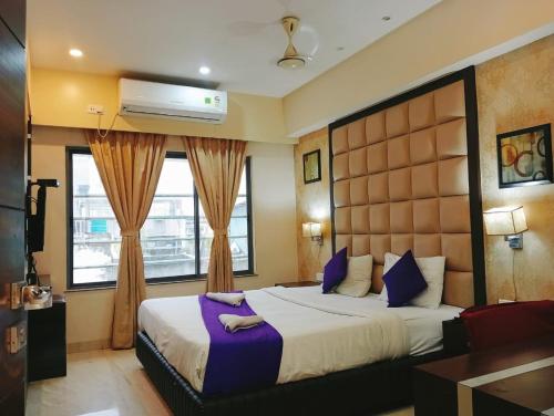 a hotel room with a large bed and a window at Hotel Radiant in Kolkata