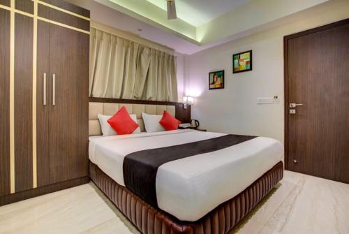 a bedroom with a large bed with red pillows at Hotel Radiant in Kolkata