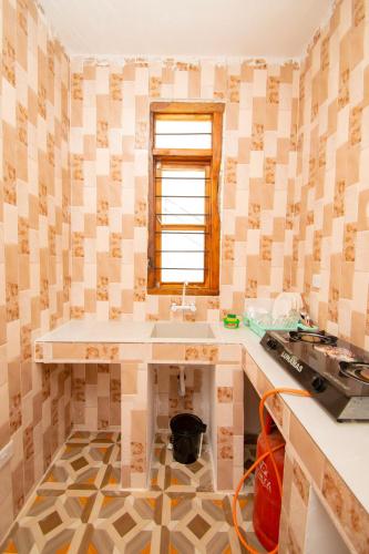 a bathroom with a sink and a window at Kigwedeni Apartments in Kinyasini