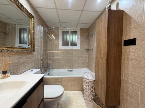 a bathroom with a tub and a toilet and a sink at Ónice de Riviera 2 in Mijas Costa