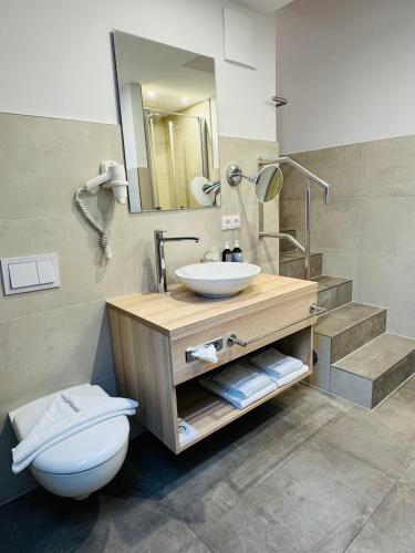 a bathroom with a sink and a toilet at Ferienhotel Alter Bahnhof garni in Prerow