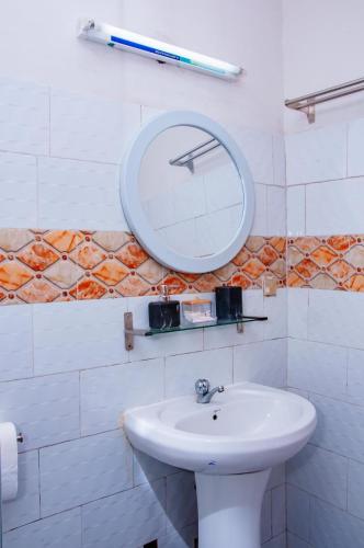 ein Badezimmer mit Waschbecken und Spiegel an der Wand in der Unterkunft Residence Mobagnes in Kinshasa