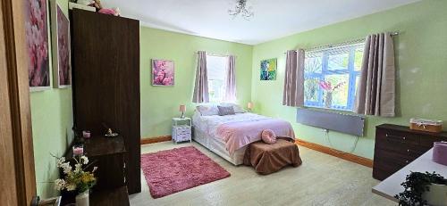 a bedroom with a bed and a pink rug at Boyne Place in East Hoathly