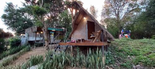 a small house with a deck in a field at Pai yard on Hill in Pai