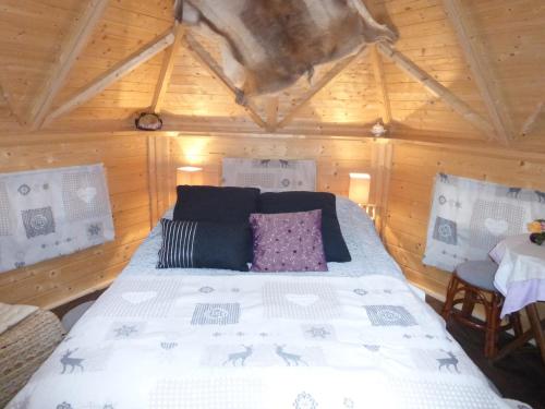 1 dormitorio con 1 cama en una habitación de madera en Abrikota, en Saint-Christophe-du-Jambet