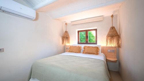 a white bedroom with a bed and a window at Claudia by Nura in Campos