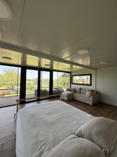 a bedroom with a large bed in a room with windows at Retreat House Mao in Petrovaradin