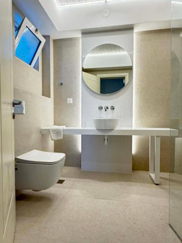 a bathroom with a sink and a toilet and a mirror at Kos Palace in Tigaki