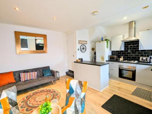 a living room with a couch and a kitchen at Stylish Townhouse - 8 Mins From Leeds - Free Fast WiFi - Free Parking in Headingley