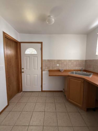 an empty kitchen with a sink and a door at ERV Club - Villas in Lixouri
