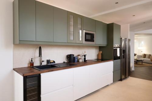 a kitchen with white cabinets and a refrigerator at Spacious Designer Duplex 9 Guests Fully Renovated in Châtillon