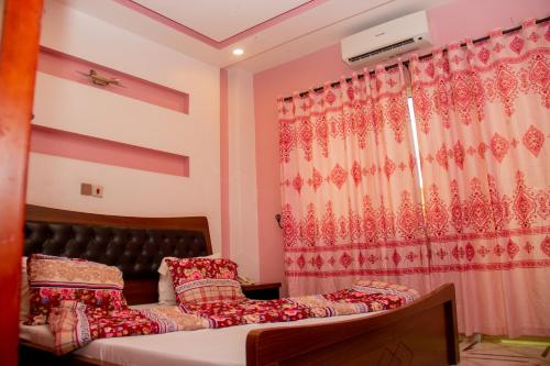 a bedroom with a bed and a curtain and a bed sidx sidx sidx at NI-FUR Hotel Cotonou in Cotonou