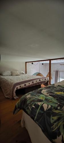 two beds are in a room withthritisthritisthritisthritisthritisthritisthritisthritisthritis at Cabanon cosy proche centre & plages-3 lits in Taglio-Isolaccio