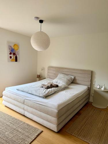 a bedroom with a white bed with a dog laying on it at Ferienwohnung LANDZEIT in Bad Soden-Salmünster