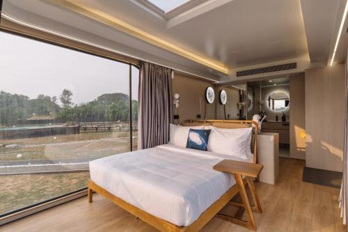a bedroom with a bed and a large window at Anchaviyo Resort in Vāda