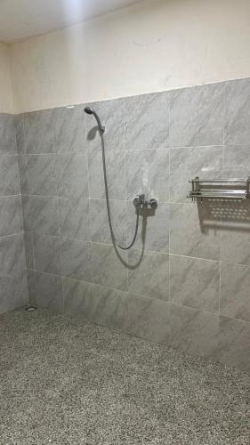 a shower in a bathroom with a tile wall at 3Z Homestay in Bayan