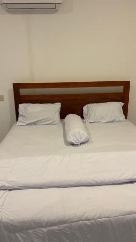 a bed with white sheets and two pillows at 3Z Homestay in Bayan