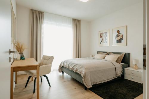 a bedroom with a bed and a table and a desk at Aria Apartments in Prievidza