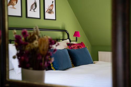 a bedroom with a bed with blue and red pillows at Riverside Cottage in Cairngorms in Ballater