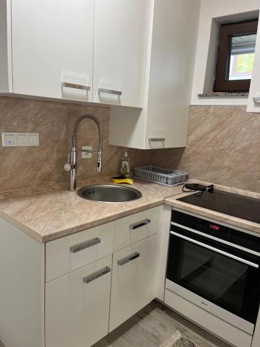 a kitchen with white cabinets and a sink at Mountain Holiday Homes in Kostel