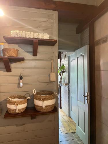 a hallway with baskets on a wall and a door at Lodge Eden, SPA Privatif in Les Abymes